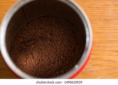 Coffee beans are ground into coffee powder by a grinder