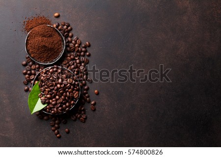 Coffee beans and ground powder on stone background. Top view with copy space for your text 