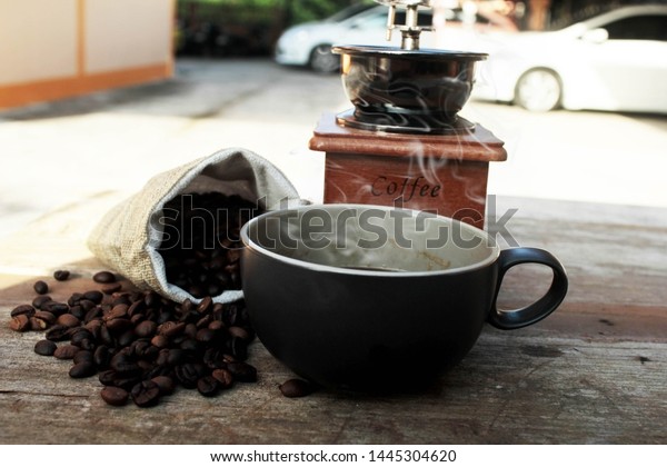Coffee beans and hot coffee bags in black ceramic\
cups look very drinkable. There is also a smoky aroma of coffee\
beans.