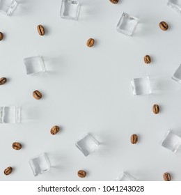 Coffee beans and ice cubes pattern on bright background. Flat lay summer drink minimal concept.