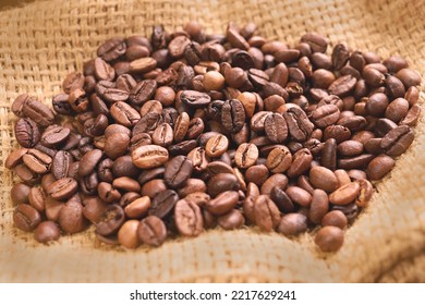 Coffee beans of medium roast coffee on on sackcloth. Arabica roast coffee beans. Toning drink, natural energetic. Beans closeup, coffee beans background. Espresso aroma, caffeine drink - Shutterstock ID 2217629241