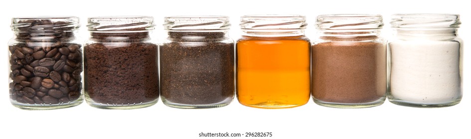 Coffee Beans, Coffee Powder, Creamer, Cocoa Powder, Honey And Processed Tea Leaves In A Mason Jar Over White Background