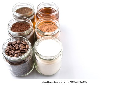 Coffee Beans, Coffee Powder, Creamer, Cocoa Powder, Honey And Processed Tea Leaves In A Mason Jar Over White Background