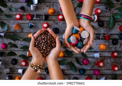 Coffee beans roasted, instant and grinded coffee in the mugs and coffee capsules in the hands of two woman. Many types of coffee on the wooden table. 