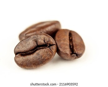 Coffee beans are Robusta. On a white background. Robusta is praised for its high caffeine content, low sugar content and low acidity. Selective focus.