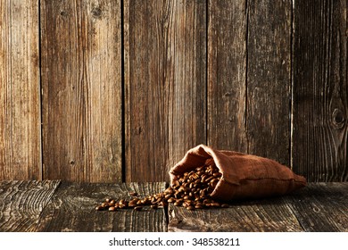 Coffee Beans In Sack On Wooden Table