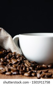 coffee beans in a sacks and empty white cup on a wooden table