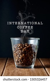 Coffee beans in a transparent glass on a wooden surface with a wording of International Coffee Day - Shutterstock ID 1505326457