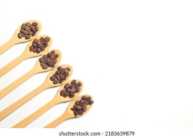 Coffee Beans In A Wooden Spoon Isolated On A White Background. Roasted Coffee Beans Isolated. A Wooden Spoon With Coffee.