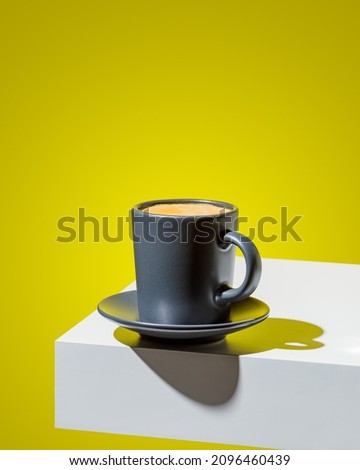 Coffee in black cup on with cubical props and lighting background