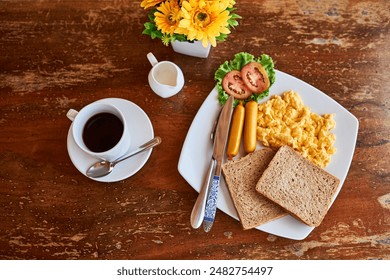 Coffee, bread and scrambled eggs on plate from above for healthy eating, breakfast and food in restaurant. Summer, flowers and meal in diner for hospitality, hosting and brunch at hotel for hunger