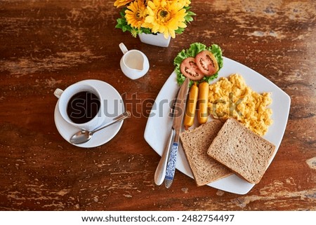 Coffee, bread and scrambled eggs on plate from above for healthy eating, breakfast and food in restaurant. Summer, flowers and meal in diner for hospitality, hosting and brunch at hotel for hunger