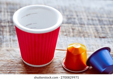 coffee break concept - empty cup with capsule coffee on wooden table
