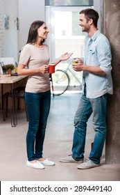 Coffee Break. Full Length Of Two Cheerful Young People Talking And Smiling During A Coffee Break In Office 