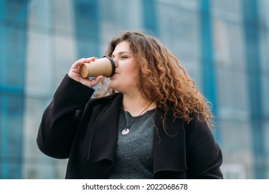 Coffee Break. Plus Size Woman. Enjoying Walk. Body Positive. Stylish Fatty Lady Drinking Hot Beverage In Paper Cup On Street City Huge Building.