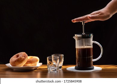 Coffee brewing in a French press pot and two donuts in plate on the wood table and warm morning light, Selective focus. - Powered by Shutterstock