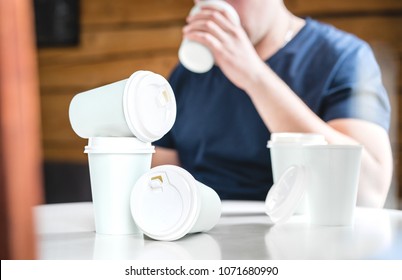 Coffee Or Caffeine Addiction Concept. Addicted Or Thirsty Man Drinking Too Much. Addict With Many Empty Take Away Paper Cups On Table. Trying To Stay Awake.