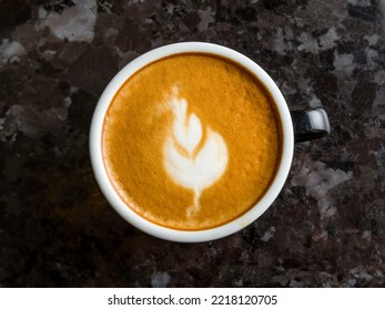 Coffee Cappuccino With Pattern On Dark Marble Table Top View