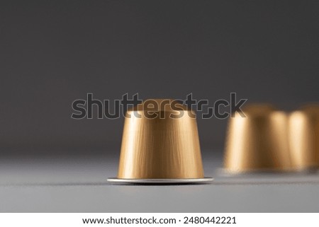 Coffee capsules in focus with others blurred in the background, creating a sense of depth