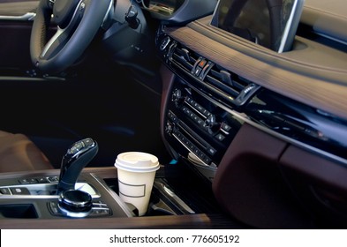 Coffee In The Car Salon. A Single Paper Coffee Cup Inside The Car Cup Holder.