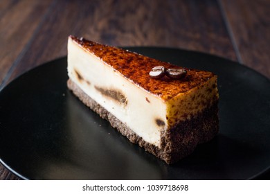 Coffee Cheesecake on Black Plate with Dark Wooden Surface. - Powered by Shutterstock