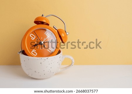 Coffee and clock on a colored background.  Time to drink coffee. Break time. Creative idea.