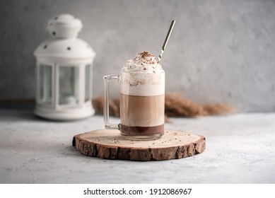 Coffee cocktail mocha with whipped cream on a wooden tray on a stone gray background. Delicious homemade sweet dessert of coffee with milk and cocoad.