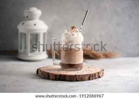 Coffee cocktail mocha with whipped cream on a wooden tray on a stone gray background. Delicious homemade sweet dessert of coffee with milk and cocoad.