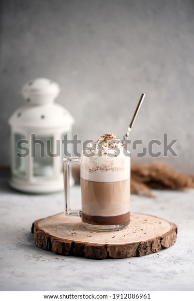 Coffee cocktail mocha with whipped cream on a\
wooden tray on a stone gray background. Delicious homemade sweet\
dessert of coffee with milk and\
cocoad.