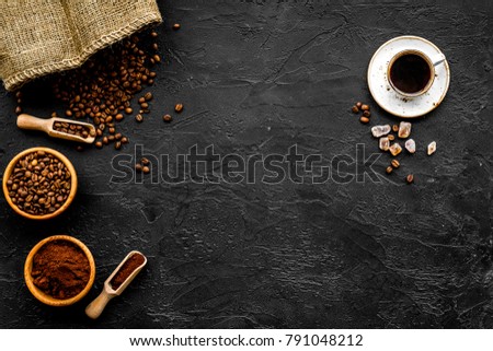 Coffee concept. Roasted beans, ground coffee, cup of espresso and sugar on black background top view copy space