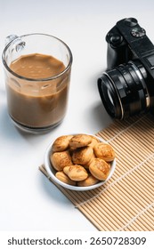 Coffee, Cookies, and Camera Setup for a Creative Break on a White Background