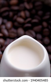 Coffee Creamer On The Background Of Dark Coffee Beans