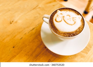Coffee cup with artistic cream cat face decoration 