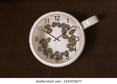 Coffee cup with coffee beans inside and a clock on top of the cup on dark background. Coffee time concept
