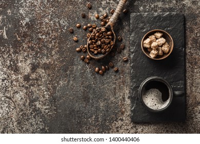 Coffee cup and coffee beans on dark stone background. Top view with copy space. Background with free text space.  - Shutterstock ID 1400440406