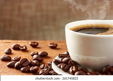Coffee cup and coffee beans on table - Shutterstock ID 261745823
