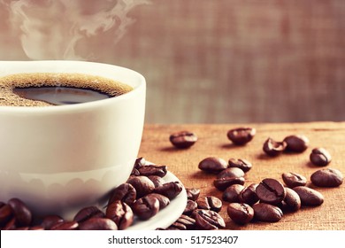 Coffee cup and beans on wooden table - Shutterstock ID 517523407
