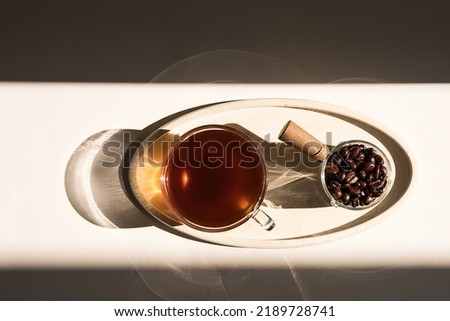 Coffee cup with beans on wooden tray. Coffee break concept.