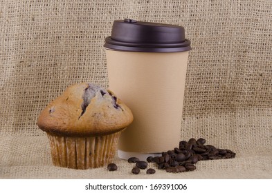 Coffee Cup And Blueberry Muffin On Jute Background.