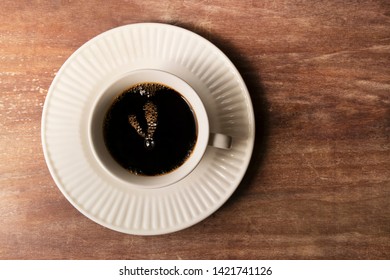 Coffee cup bubbles on plate with eleven o' clock time.