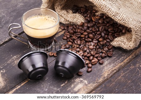 Coffee cup and capsules on a rustic wooden table