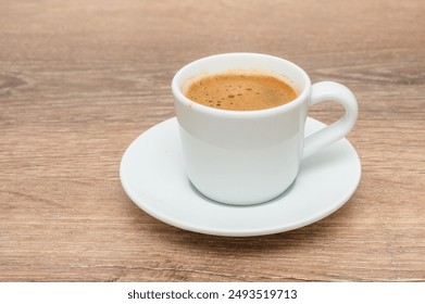 A coffee cup is elegantly placed on a saucer atop a wooden table - Powered by Shutterstock