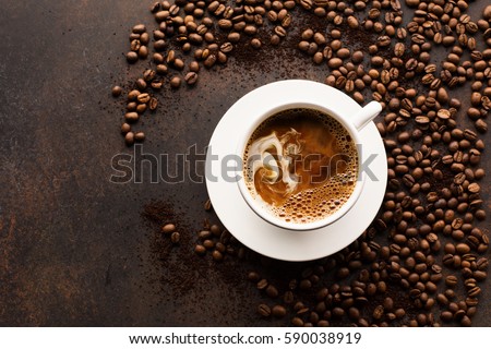 Coffee cup espresso and poured milk or cream on old retro dark background with beans. Top view with copy space for text. Breakfast coffee love concept