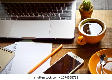 Coffee cup hot and notebook pen laptop on wooden table desk
