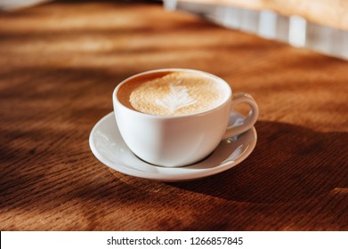 coffee cup latte art in cafe on wooden table