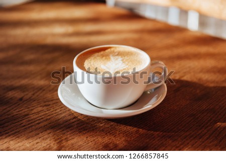coffee cup latte art in cafe on wooden table