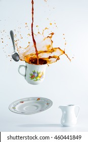 Coffee Cup Levitate Above The Table With The Coffee Spill From The Cup.