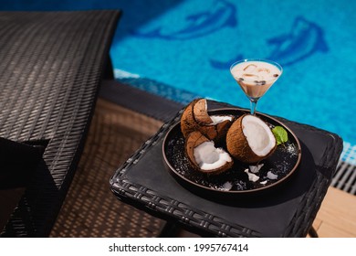 Coffee In A Cup Next To Coconut Slices Served On A Poolside Side. Summer Refreshing Drink By The Pool