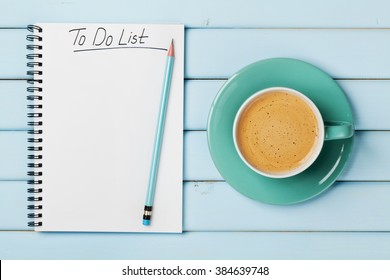 Coffee cup and notebook with to do list on blue rustic desk from above, planning and design concept - Powered by Shutterstock