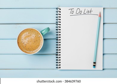 Coffee cup and notebook with to do list on blue rustic desk from above, planning and design concept - Shutterstock ID 384639760